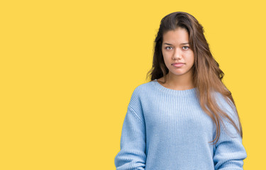 Young beautiful brunette woman wearing blue winter sweater over isolated background skeptic and nervous, frowning upset because of problem. Negative person.