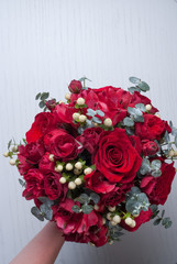 Red bouquet of red roses. Wedding flowers on gray background. Selective focus