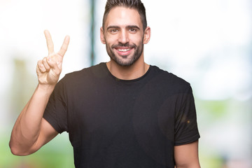 Naklejka premium Young handsome man over isolated background showing and pointing up with fingers number two while smiling confident and happy.