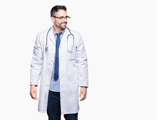 Handsome young doctor man over isolated background looking away to side with smile on face, natural expression. Laughing confident.