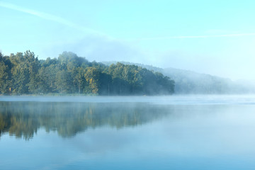 Fototapeta na wymiar Morning fog on the lake on a summer day