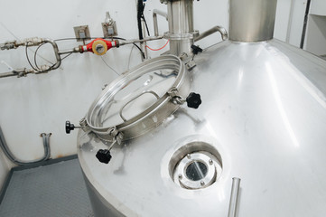 Modern brewery and equipment machinery tools for alcohol production. Steel vats or tanks and stainless pipes.
