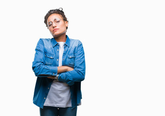 Young braided hair african american girl wearing glasses over isolated background skeptic and nervous, disapproving expression on face with crossed arms. Negative person.