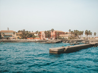 Senegal beach with concrete pier and architecture, view from water