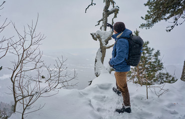 man with a backpack on top of a snowy mountain