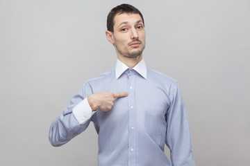It's me. Portrait of proud handsome bristle businessman in classic light blue shirt standing, pointing himself and looking at camera. indoor studio shot, isolated on grey background copyspace.