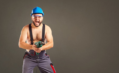 Funny builder with a drill in his hands.