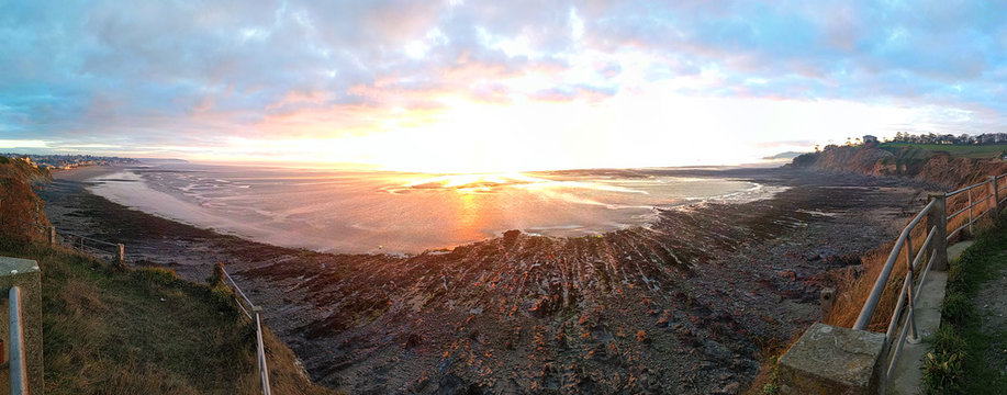 Panorama d'un coucher de soleil sur la mer &agrave; mar&eacute;e basse