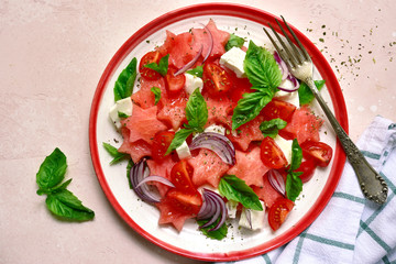 Watermelon salad with tomato, feta cheese, red onion and basil.Top view with copy space.