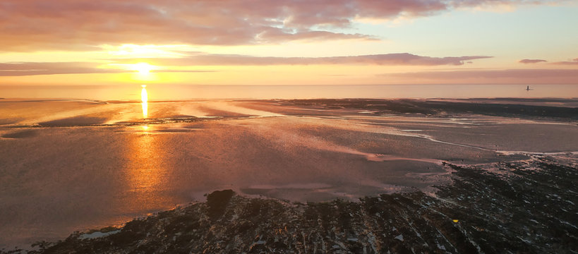 Coucher de soleil sur la plage &agrave; mar&eacute;e basse