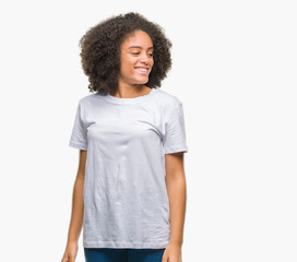 Young afro american woman over isolated background looking away to side with smile on face, natural expression. Laughing confident.