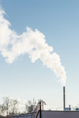 Clouds of smoke from the industrial chimney against sky. Air pollution, environmental issues.