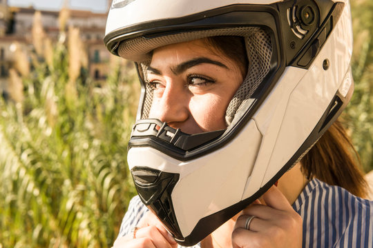 Close-up teenage girl fastening crash helmet