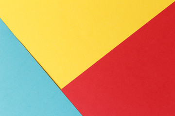 Abstract geometric festive background: red, yellow, blue. Paper background top view, minimalistic concept.