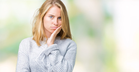 Beautiful young woman wearing winter sweater over isolated background thinking looking tired and bored with depression problems with crossed arms.