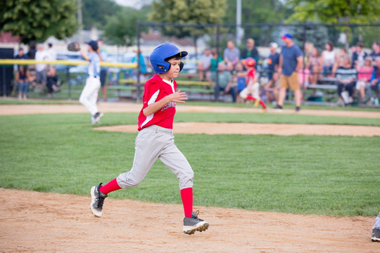 Full length of boy running on ground while playing baseball