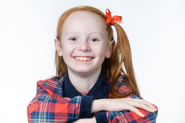 Red-haired girl sitting at a school desk in front of a white background
