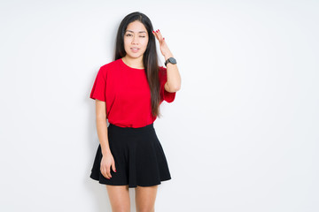 Beautiful brunette woman wearing red t-shirt and skirt over isolated background winking looking at the camera with sexy expression, cheerful and happy face.
