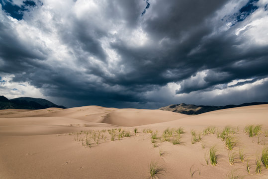 View of desert against stormy clouds at Great Sand Dunes National Park and Preserve