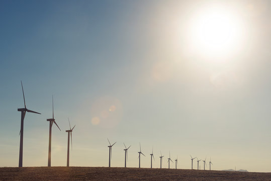 Windmills in field against clear sky