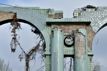 Broken clock and lantern at the entrance of ruined old abandoned engineering plant,Odessa,Ukraine