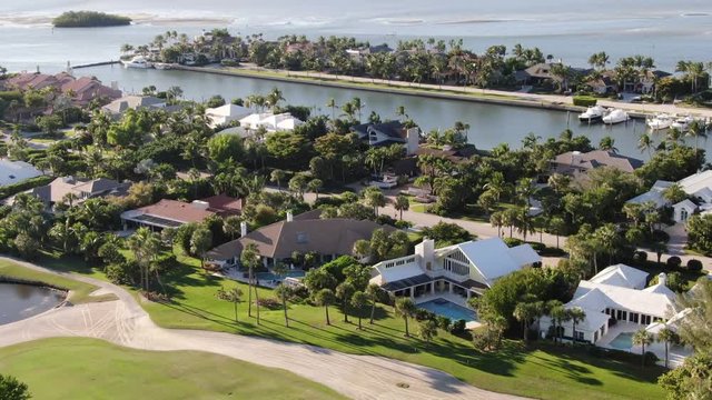 Aerial of luxury homes lining Port St. Lucie's waterfront, with views of private boat docks, golf courses and the Atlantic Ocean.