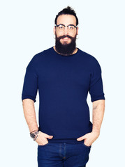 Fototapeta premium Young hipster man with long hair and beard wearing glasses with a happy and cool smile on face. Lucky person.