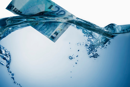 Euro banknote sinking in water as symbol of economic crisis Europe.