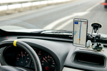 Fototapeta premium Travel by car with a navigator in a mobile phone in the winter