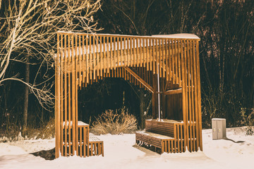 Wooden arbor in a snowy winter night park