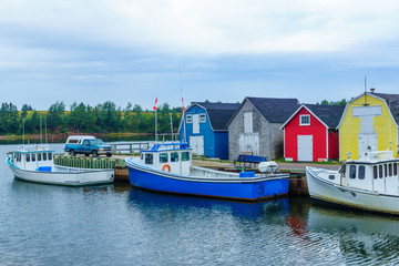 Fototapeta na wymiar Pier, fishing boats and colorful houses, PEI
