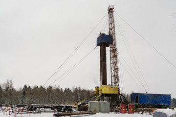 Fototapeta premium Oil and Gas Drilling Rig onshore dessert with dramatic cloudscape. Oil drilling rig operation on the oil platform in oil and gas industry. Land oil drilling rig blue sky