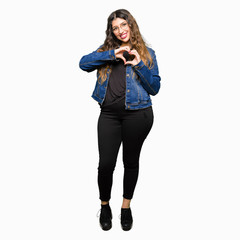 Young beautiful woman wearing glasses and denim jacket smiling in love showing heart symbol and shape with hands. Romantic concept.