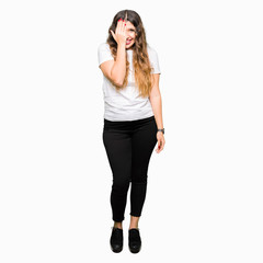 Fototapeta premium Young beautiful woman wearing casual white t-shirt covering one eye with hand with confident smile on face and surprise emotion.