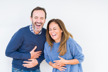 Beautiful middle age couple in love over isolated background Smiling and laughing hard out loud because funny crazy joke. Happy expression.