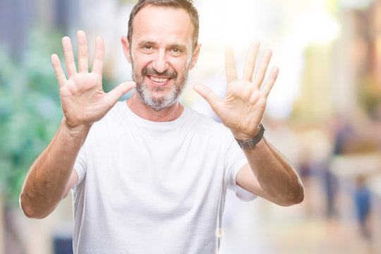 Middle age hoary senior man wearing white t-shirt over isolated background showing and pointing up with fingers number ten while smiling confident and happy.
