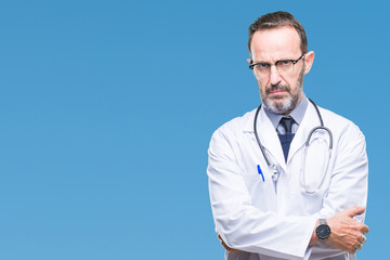 Middle age senior hoary doctor man wearing medical uniform isolated background skeptic and nervous,...
