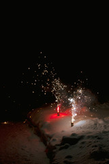 Bright colorful multicolored fireworks fountain in the snow at night