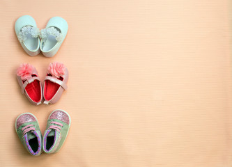Many cute baby shoe placed on pink background , top view