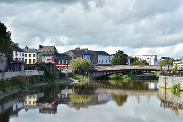 Fototapeta na wymiar Calm river Nore reflecting historical buildings in Kilkenny on its surface.