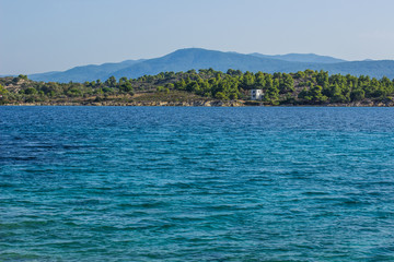 Fototapeta na wymiar tropic picturesque forest island shoreline coast with small cottage near sea lagoon vivid blue water surface