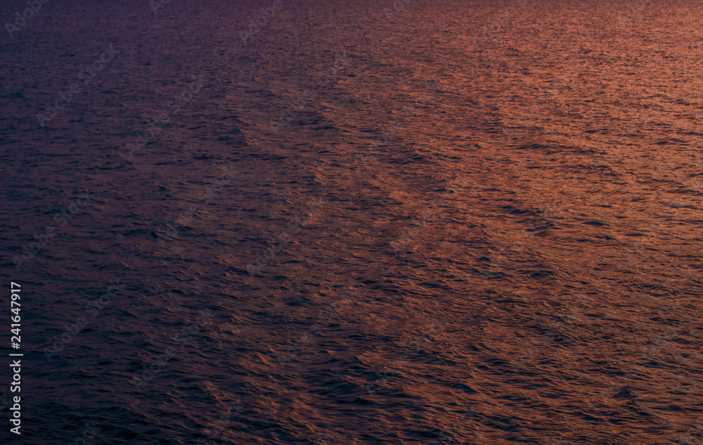 Wall mural abstract unfocused background of fuzzy water waves surface in sunset evening twilight  