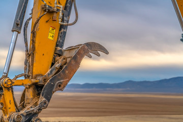 Claw of an excavator arm close up field behind