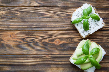 Avocado sandwiches with philadelphia cheese and basil leaves, free space for text, copy space.