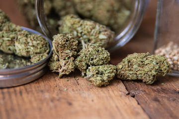 Marijuana Bud Flowers In Glass Jar Up Close On Natural Wood