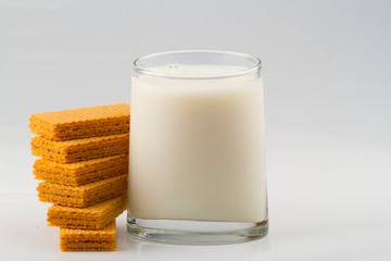 glass with milk and wafer cookies isolated on white background