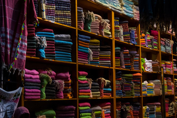 Fototapeta na wymiar The colorful cloacks on the shelves in the store
