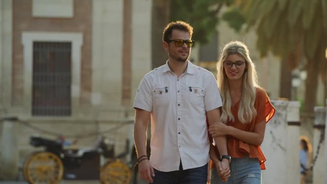 Slow motion of couple holding hands and walking in city / Seville, Sevilla, Spain