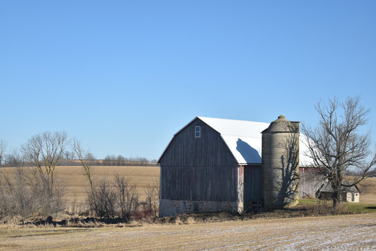 Vintage old barn with silo in late autumn on a sunny day on a farm in the country - Powered by Adobe