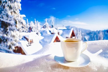 Cup of coffee on amazing winter mountain landscape background